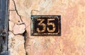 Number 35 on wall sign, rusty and weathered. Royalty Free Stock Photo