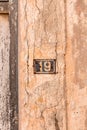 Number 19 on wall sign, rusty and weathered. Royalty Free Stock Photo