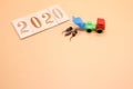 2020 number was lined with wooden figures. A toy dump truck brought and dumped three small metal mice next to it Royalty Free Stock Photo