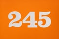 Number 245 - White digits on orange background Royalty Free Stock Photo