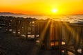 Number of wooden gazebos with curtains cut through the rays of the setting sun on the beach. Europe, Crete, Greece Royalty Free Stock Photo
