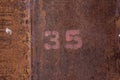 The number written on the rusty metal plating