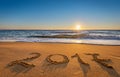 Number 2017 written on seashore sand at sunrise.