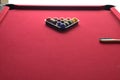 Numbered billiard balls in a black ball rack on a red felt pool table with a cleaning brush Royalty Free Stock Photo