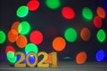 Numbers 2021 on a blurry background of holiday colorful lights. Christmas lights, beautiful bokeh. Greeting card. The concept of Royalty Free Stock Photo