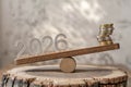 2026 Numbers and Coins on Wooden Log Balance Scale for Financial Outlook Royalty Free Stock Photo