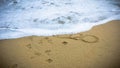 Numbers 2020 disappear on the sea shore, message handwritten in the golden sand on beautiful beach background Royalty Free Stock Photo