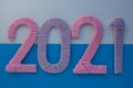 The numbers 2021 are made of pink and lilac threads on a blue and white background. The concept of a New year Royalty Free Stock Photo