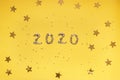 2020 numbers from small confetti with shining stars . Festive background. New Year. Top view.