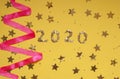 2020 numbers from small confetti with shining stars . Festive background. New Year. Top view. Royalty Free Stock Photo