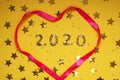 2020 numbers from small confetti with shining stars and a pink heart. Festive background. New Year. Top view. Royalty Free Stock Photo