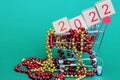 The numbers 2022 in a supermarket toy cart . New year`s number 2021 in red numbers on wooden blocks among Christmas beads Royalty Free Stock Photo