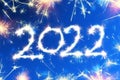 Numbers 2022 symbol inscription on a background of a dark night sky from flashes of sparklers, candies from sparks. Festive