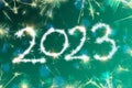 Numbers 2023 symbol inscription on a green, turquoise background of a dark night sky from flashes of sparklers, candies from