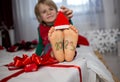 numbers 2023 are written on boy's bare feet, child wears a little Santa hat on his toes