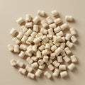 Numerous beige cylindrical packing peanuts scattered on a smooth, beige surface. Royalty Free Stock Photo