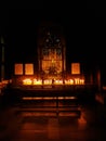 Numerous candles enlight the solemn catholic chapel`s altar