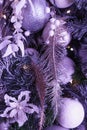 Numerous decorative tinsels on Christmas tree in violet tone. Color of 2022. Very Peri pantone