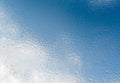 Numerous drops of morning dew on the window glass against the backdrop of a blue sky with clouds Royalty Free Stock Photo