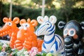 Numerous fake animals and figurines embellish a table, creating a playful and whimsical display, Animal-shaped balloons at a zoo-