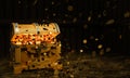 Numerous gold coins spilled out from the treasure chest. Old-style wooden treasure chest tightly assembled with rusted metal