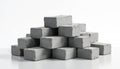Numerous grey rectangular rough bricks stacked in pyramid shape on white. Concrete building blocks piled on reflective surface. Royalty Free Stock Photo