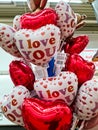 Numerous heart-shaped balloons with the inscription I Love You for sale at a stand