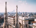 Numerous statues on steeples Duomo di Milano watches on city lif