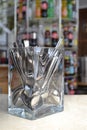 Numerous teaspoons placed in a solid glass container placed on a counter in a bar. Royalty Free Stock Photo