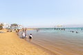 Numerous visitors relax on a comfortable beach on the coast of the Dead Sea in southern Israel