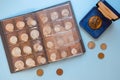 Numismatics. Old and expensive ancient collectible coins made of silver, gold and copper in a transparent plastic album on blue