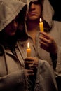 Nun and monk praing with candles