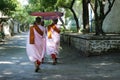 Nun with pink robe and umbrella, in the streets of Mandalay