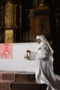 Nun ringing bells during consecration Royalty Free Stock Photo