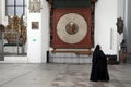 A nun walks in front of the Gdansk astronomical clock in the Basilica of St. Mary in GdaÃâsk, Poland Royalty Free Stock Photo