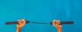 Nunchaku holding on hand isolated on Blue background. Black nunchaku training for beginner. Hot Tactical Gear Martial Arts