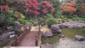 Nuno-ochi falls surrounded by rocks overlooked by momiji maple trees in the Japanese Ohori garden a rainy day.