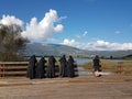 Nuns sisters in black greek orthodox religion in sunny day looking at a lake