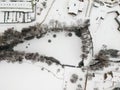 Nupaky, Czech republic - February 09, 2021. Aerial view of small frozen pond in winter under the snow with trees around