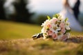 Nuptial scene Wedding bouquet rests on grass with married couple