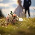 Nuptial scene Wedding bouquet rests on grass with married couple