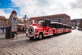 Red tourist trolley takes passengers on a sightseeing tour around the famous streets of