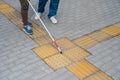 A nurse accompanies a blind woman outdoors.