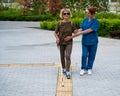 A nurse accompanies an elderly blind woman on a walk. Royalty Free Stock Photo