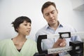 Nurse Adjusting Weighing Scale For Man