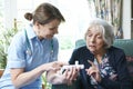 Nurse Advising Senior Woman On Medication At Home Royalty Free Stock Photo