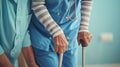 a nurse aids an elderly woman in standing up, their hands firmly gripping her walking stick, both dressed in a blue