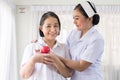 Nurse and Asian elderly woman holding heart red model on hands together,Senior healthy and taking care concept Royalty Free Stock Photo