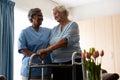 Nurse assisting senior patient in walking with walker Royalty Free Stock Photo