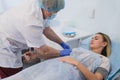 Nurse attaching intravenous tube to patient`s hand in hospital bed